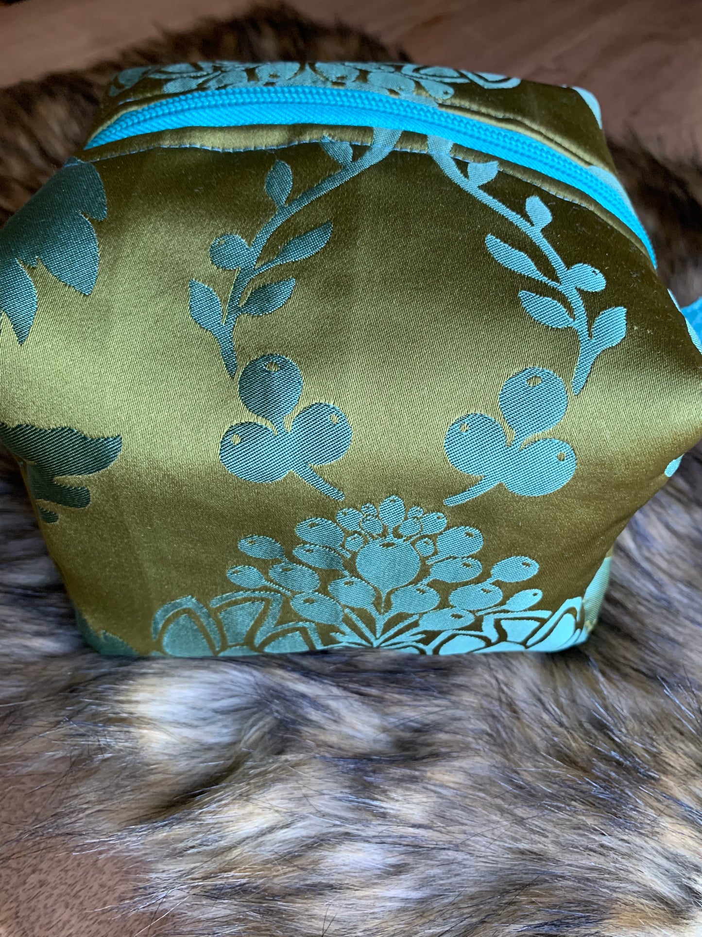 Nesting essentials travel cosmetic bag in an olive/turquoise silk artichoke stylized motif. You must feel this fabric! Turquoise zipper and thumb handles. Fully lined with 100% cotton. Hand wash as needed.So cute, you must have it.