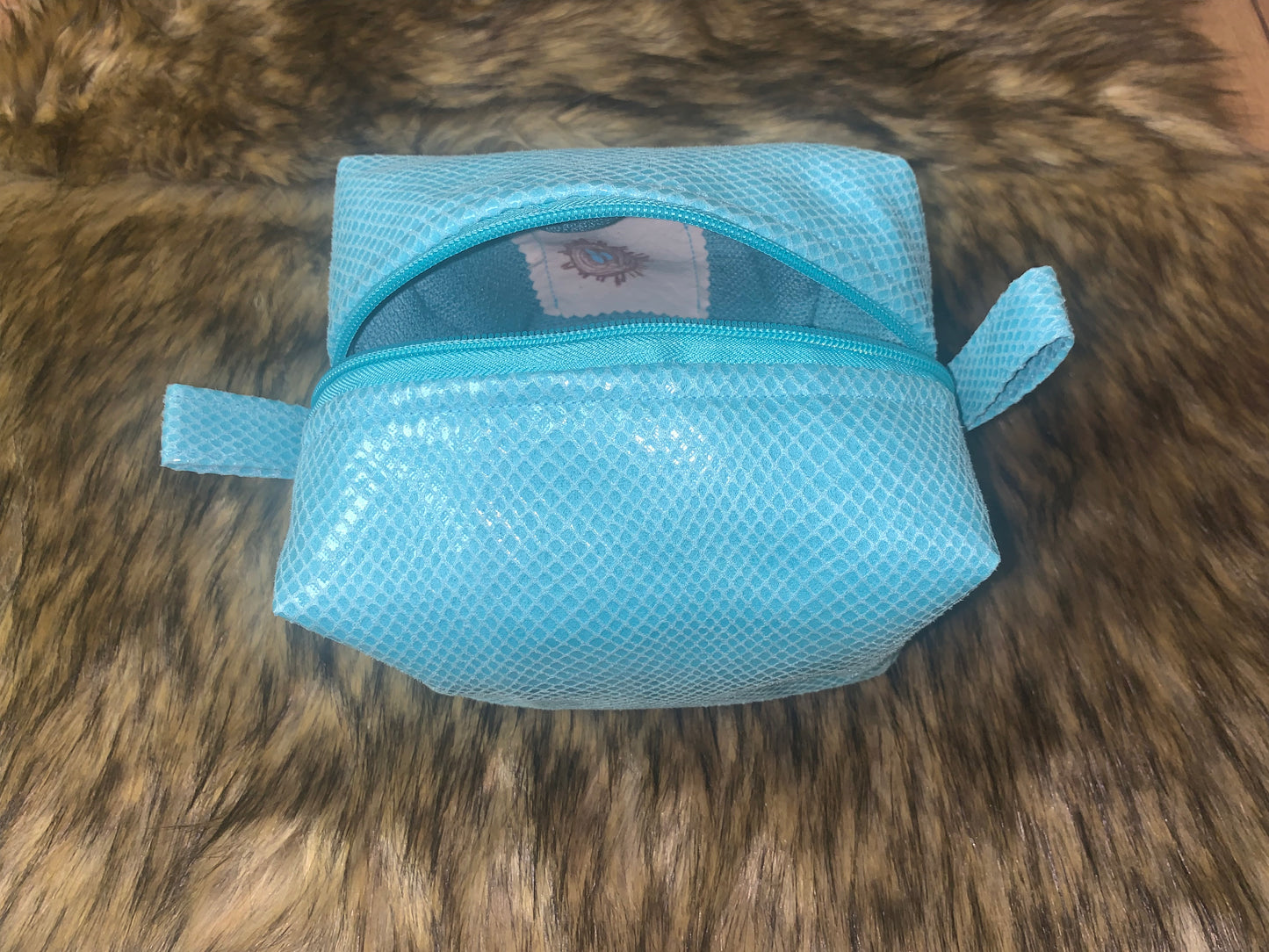 Caribbean Ocean colour faux reptile fabric. Fully lined with 100% cotton. Turquoise easy pull zipper, and thumb handles. Super cute travel essential bag. 