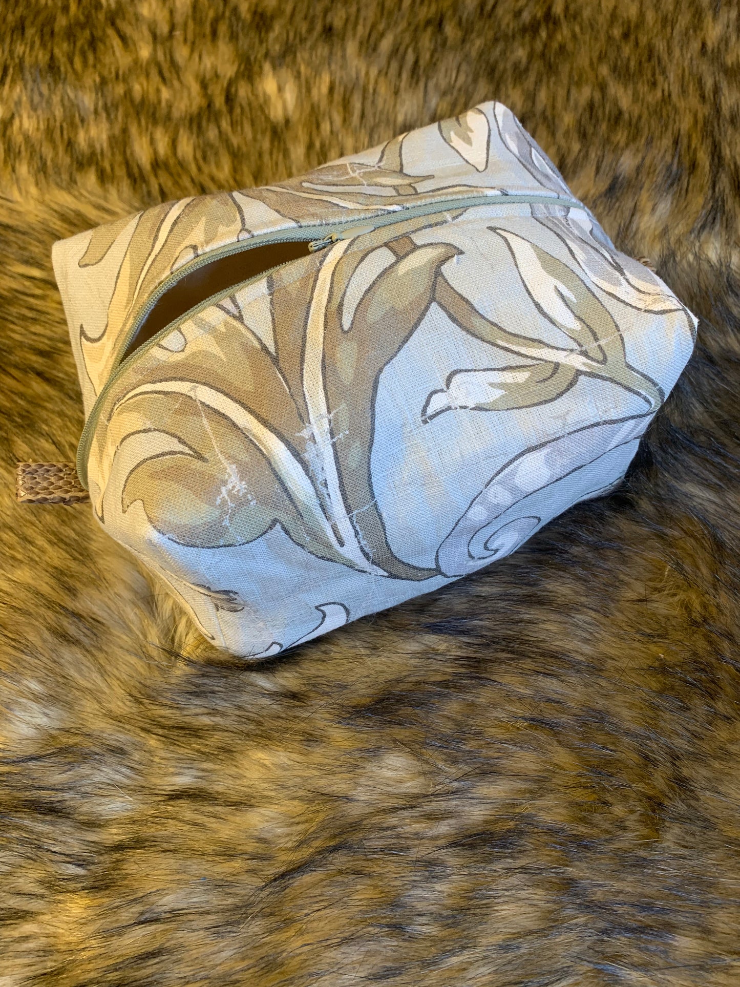 Unique handmade cosmetic toiletry bag made with a luxury Interior Design Linen fabric in the colors of Winter. Soft blue background and snowy tan foliage. This bag is lined with 100% cotton and has leather thumb tabs. Hand wash as needed. Traveling soon? Buy this now. 