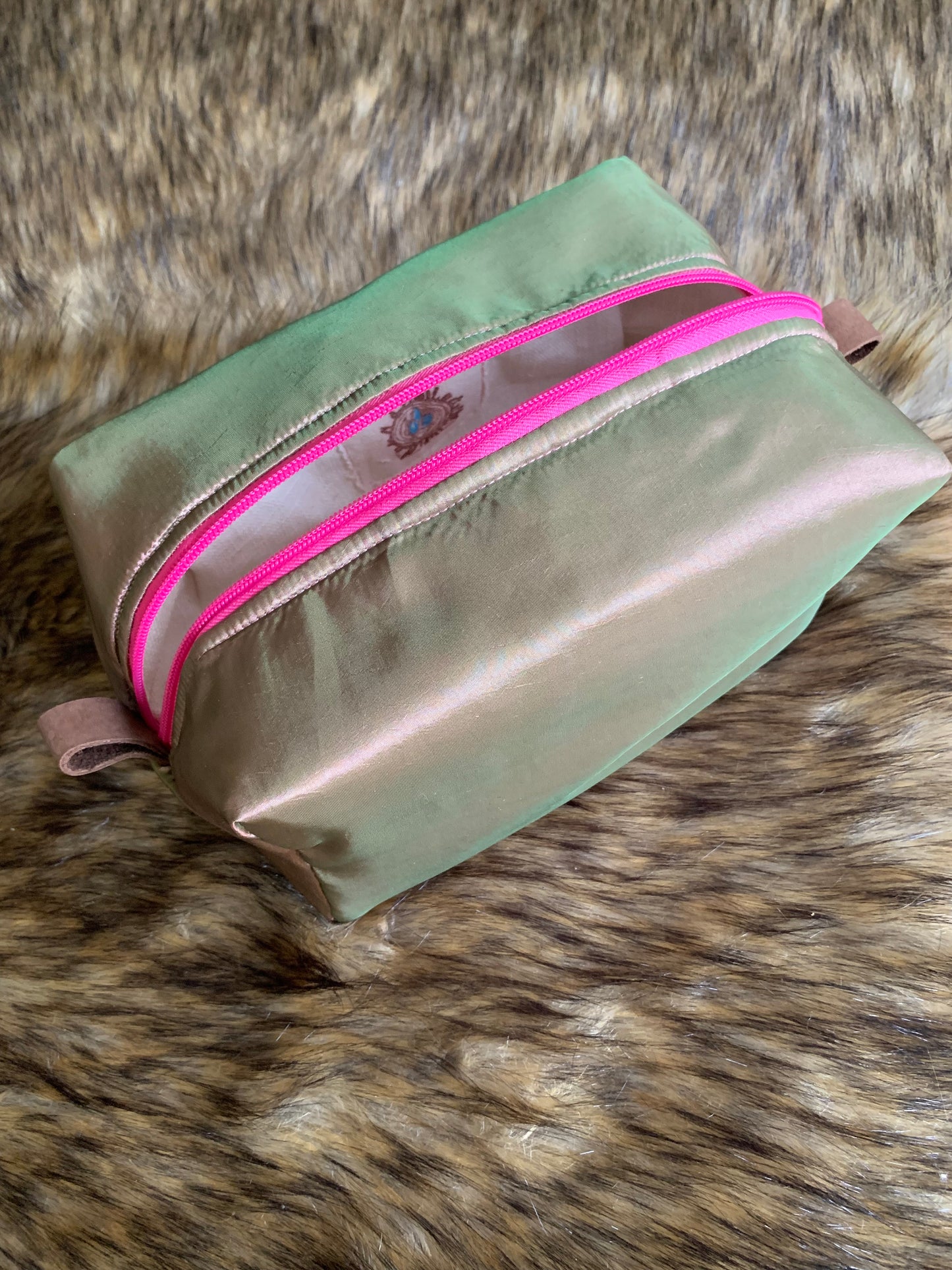 This is a elegant iridescent pink, green and tan yummy, embracing the jewel tones celebrating each day. Bright pink zipper and soft leather thumb handles make use a breeze. Each Nesting Essentials is fully lined and padded with unbleached 100% cotton. Hand wash as needed. Make caring for your personal self a glamorous affair.&nbsp;