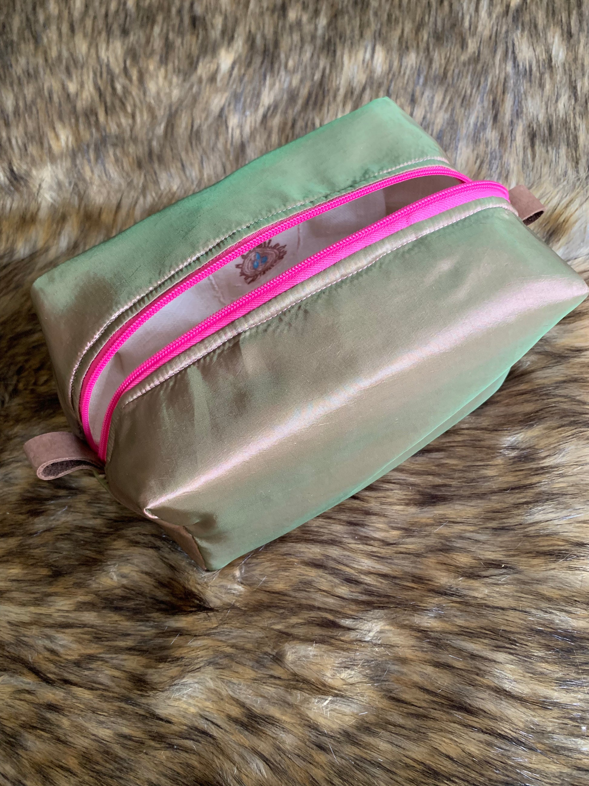 This is a elegant iridescent pink, green and tan yummy, embracing the jewel tones celebrating each day. Bright pink zipper and soft leather thumb handles make use a breeze. Each Nesting Essentials is fully lined and padded with unbleached 100% cotton. Hand wash as needed. Make caring for your personal self a glamorous affair.&nbsp;