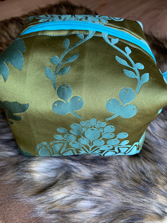 Nesting essentials travel cosmetic bag in an olive/turquoise silk artichoke stylized motif. You must feel this fabric! Turquoise zipper and thumb handles. Fully lined with 100% cotton. Hand wash as needed.So cute, you must have it. 