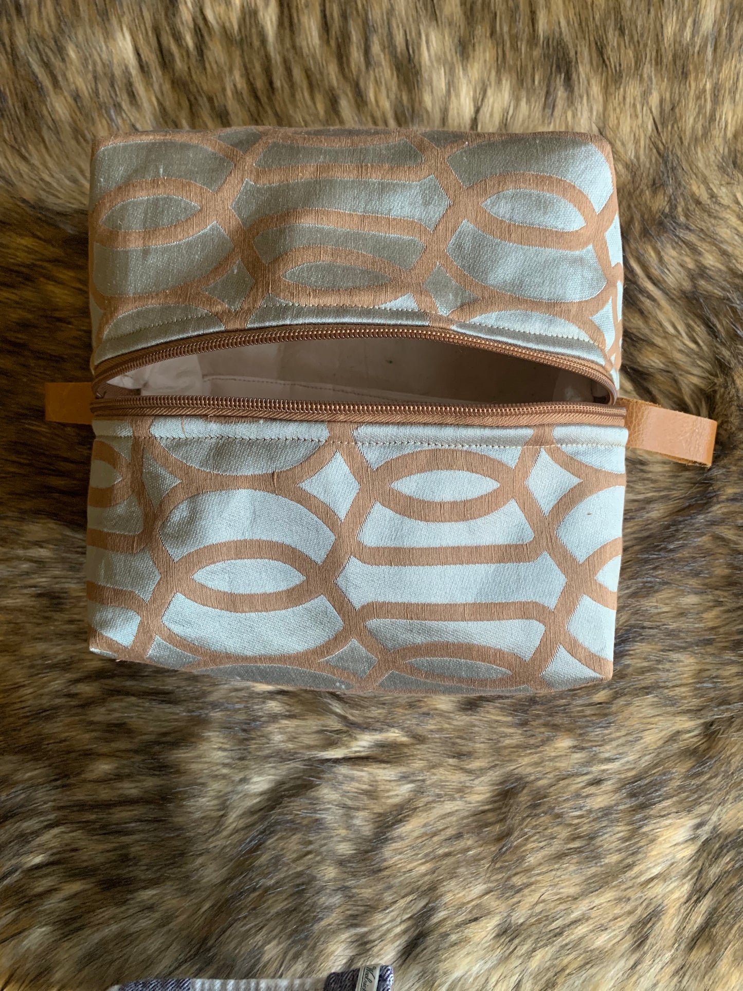 Nesting essentials travel cosmetic bag.
Soft teal shimmering Deco silk fabric with an overlayed flat embroidery in tan colour. Tan zipper and tan leather thumb handles. Square shape for larger collection. 