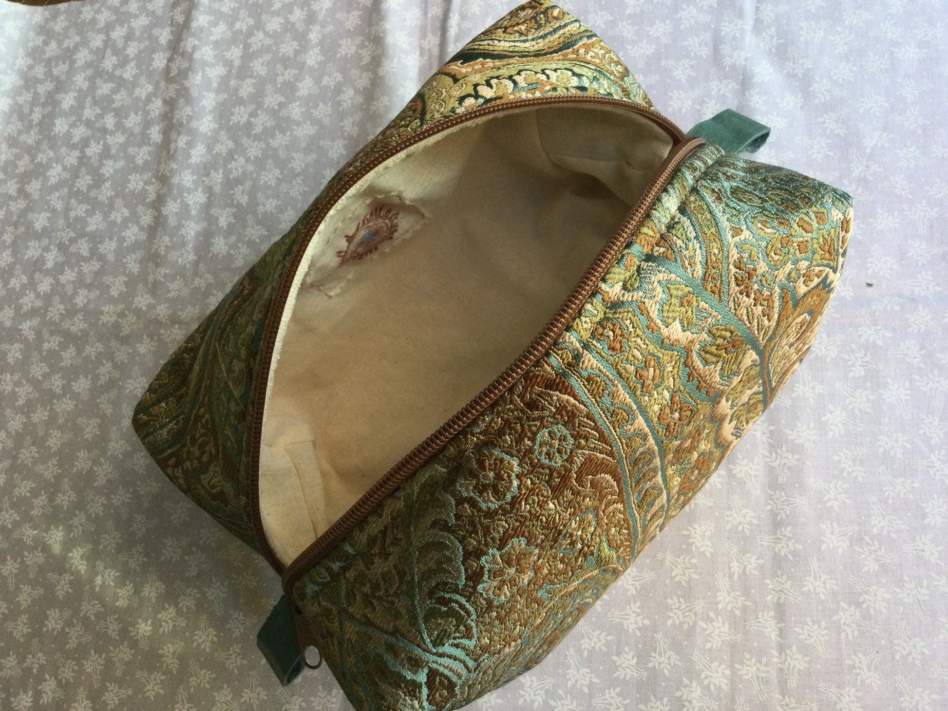 est all of your precious essentials together with elegance. This is a stunning silk in the calming coastal tones, Tan or Teal zipper and leather thumb handles make use a breeze. A Silk embracing the rich coastal tones to celebrate each day. Each Nesting Essentials is fully lined and padded with unbleached 100% cotton. Hand wash as needed. Make caring for your personal self a glamorous affair.&nbsp;